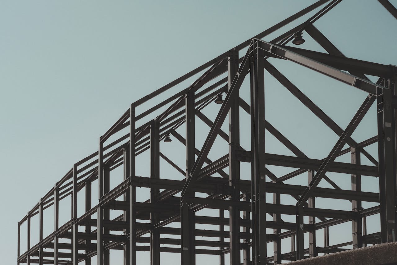 services-01 Modern steel framework structure under clear sky, showcasing architectural design.